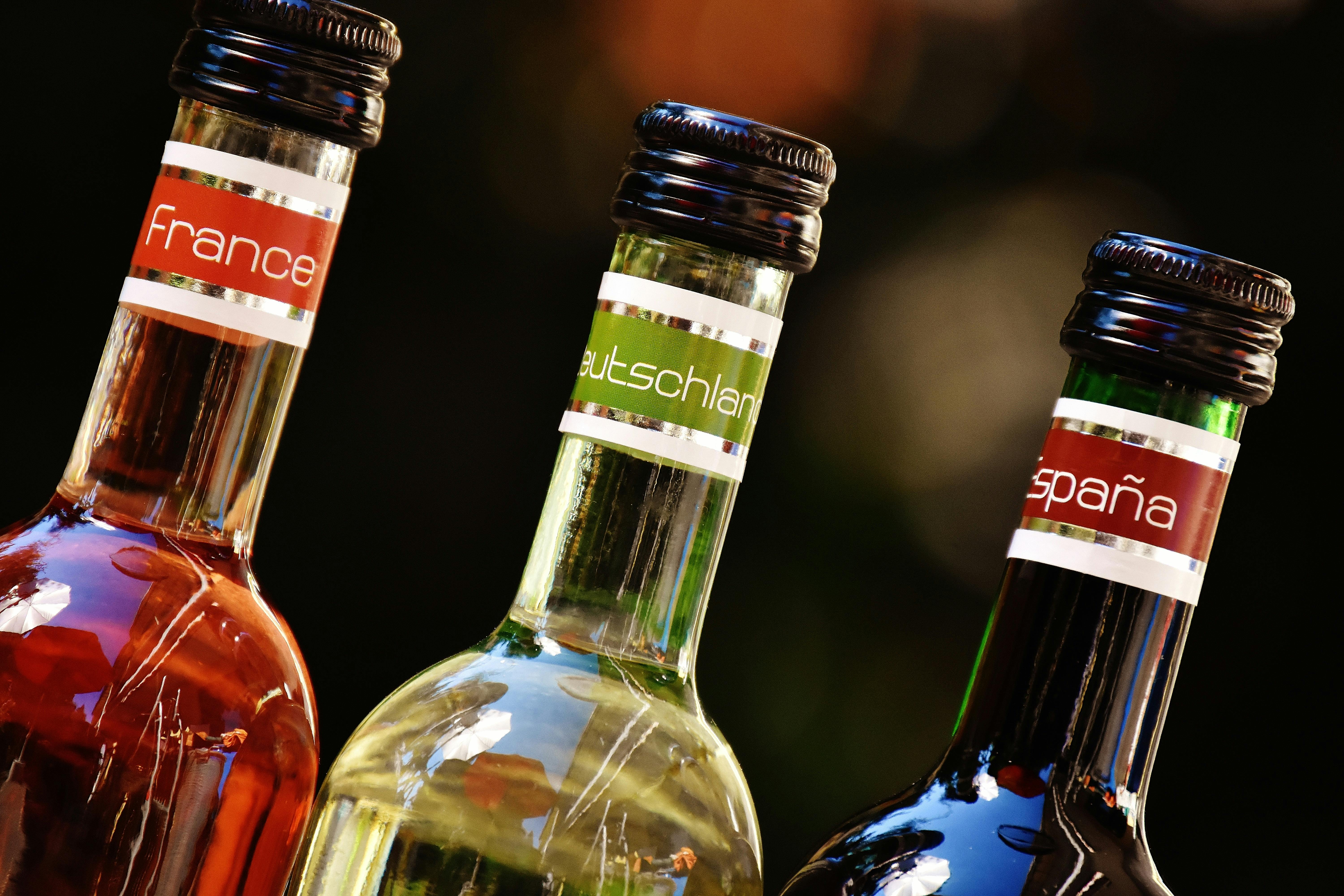 Three wine bottles with labels from France, Germany, and Spain, showcasing diverse wine cultures.